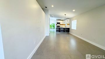 Miami house for rent - A spacious room with a kitchen area in the background.