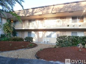 Lantana apartment for rent - A building with a balcony and a garden in front.