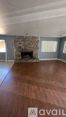 Idyllwild Pine Cove house for rent - A room with a stone fireplace and wooden floors.
