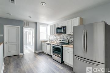 Baltimore house for rent - A kitchen with white appliances and a grey wall.