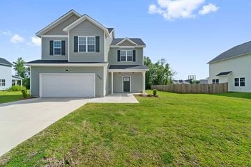 Jacksonville house for rent - A two-story house with a garage is surrounded by a well-maintained lawn.