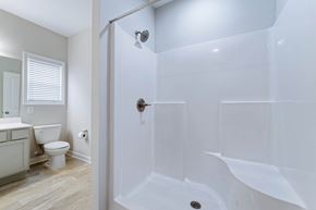 Jacksonville house for rent - A white bathroom with a toilet, sink, and shower.