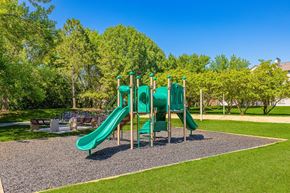 Buffalo Grove apartment for rent - A playground with a green slide and a gravel area in the foreground.