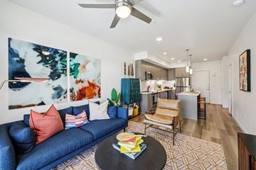 Grand Prairie apartment for rent - A living room with a blue couch and a painting on the wall.