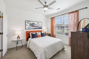 Grand Prairie apartment for rent - A bedroom with a large bed and a ceiling fan.
