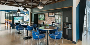 Grand Prairie apartment for rent - A modern dining area with a round table surrounded by blue chairs.