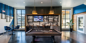 Grand Prairie apartment for rent - A billiard table is in the middle of a room with a television and a pool table.