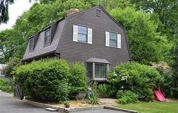 Marblehead apartment for rent - A house with a grey exterior and a red slide in the yard.