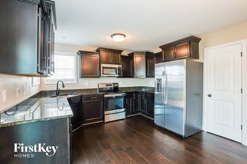 Clarksville house for rent - A kitchen with dark brown cabinets and a FirstKey Homes logo.