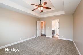 Clarksville house for rent - A spacious room with a ceiling fan and carpeted floor.