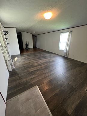 Grinnell house for rent - A room with wooden flooring and a window with curtains.