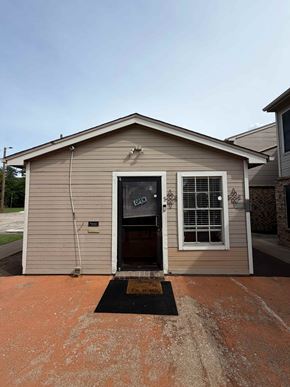 Mansfield apartment for rent - A small building with a black door and a window is shown.