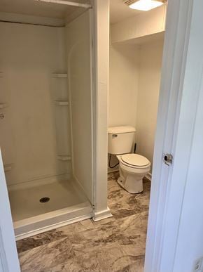 Bay City apartment for rent - A white toilet sits in a bathroom next to a walk-in shower.