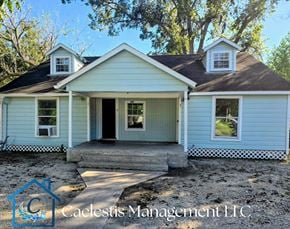 Bay City apartment for rent - A blue house with a porch and a logo for Calecestis Management LLC.