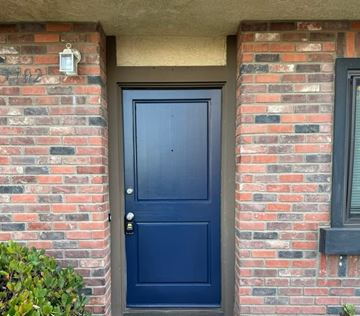 Oxnard apartment for rent - A blue door is set in a brick wall.