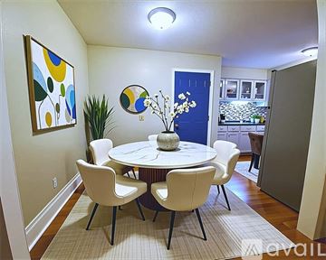 Muskegon apartment for rent - A living room with a couch, a chair, a dining table, and a painting on the wall.