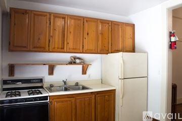 Gainesville apartment for rent - A kitchen with wooden cabinets and a white refrigerator.