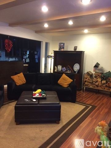 San Diego house for rent - A living room with a black couch and a coffee table.
