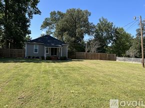 Stanton house for rent - A small house with a porch is surrounded by a fence and trees.