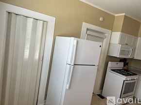 Stanton house for rent - A white refrigerator stands in a kitchen with a white oven and microwave.