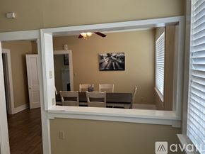 Stanton house for rent - A dining room with a white table and chairs is visible through a window.