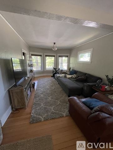 Portland house for rent - A living room with a brown leather couch and a rug.