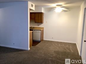 Knoxville apartment for rent - A carpeted room with a kitchen area and a door.