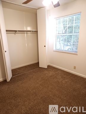 Knoxville apartment for rent - A small bedroom with a window and a white door.
