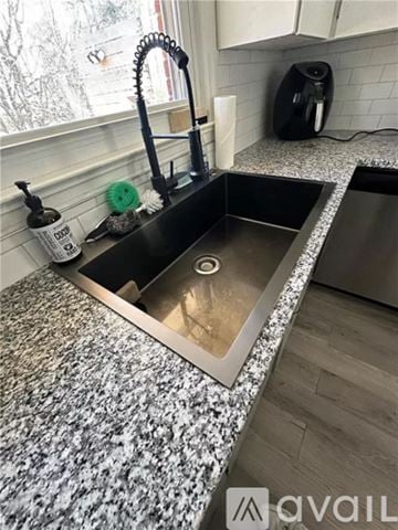 Smyrna house for rent - A kitchen sink with a black faucet and a black coffee maker on the counter.