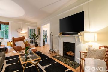 Savannah house for rent - A living room with a fireplace and a large television mounted above it.