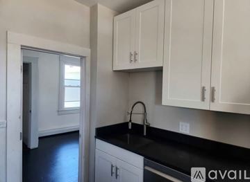 Portland apartment for rent - A kitchen with white cabinets and a black countertop.