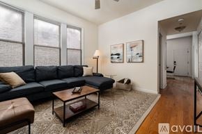 Chicago apartment for rent - A living room with a blue couch, a coffee table, and a rug.