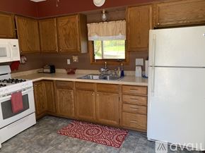 Bemidji house for rent - A kitchen with wooden cabinets and a white refrigerator.