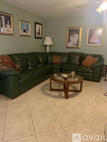 Cutler Bay house for rent - A living room with a green couch and a coffee table.