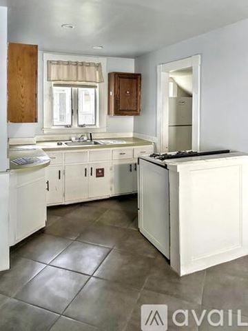 Fitchburg apartment for rent - A kitchen with white cabinets and a tile floor.