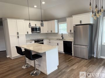 Jonesboro house for rent - A modern kitchen with white cabinets and a central island.