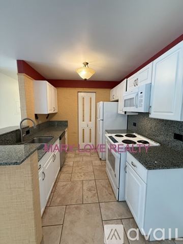 Kailua Kona apartment for rent - A kitchen with white cabinets and a granite countertop.