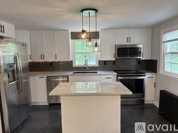 Leicester house for rent - A kitchen with white cabinets and a central island.