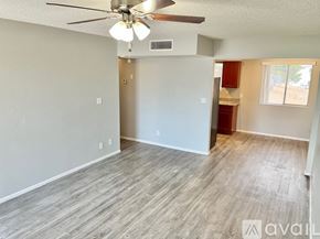 Phoenix apartment for rent - A room with a ceiling fan and light fixture, and a window with blinds.