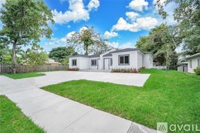 Miami house for rent - A house with a white exterior and a green lawn in front.