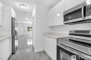 Miami house for rent - A modern kitchen with stainless steel appliances and white cabinets.