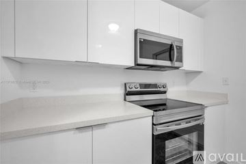 Miami house for rent - A modern kitchen with a microwave on top of the oven.