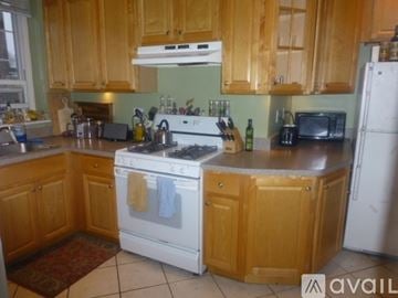 Brookline apartment for rent - A kitchen with wooden cabinets and a white stove top oven.