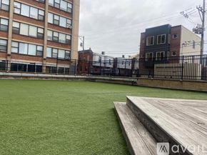 Philadelphia apartment for rent - A green artificial turf soccer field with a wooden platform in front of a brick building.