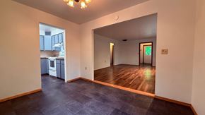 Sitka house for rent - A room with a wooden floor and a chandelier.