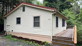 Sitka house for rent - A house numbered 201 with a red roof and a deck.