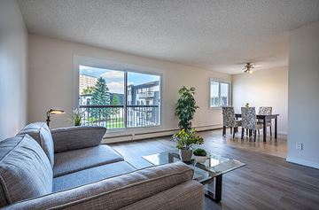 Edmonton apartment for rent - A living room with a grey couch and a glass coffee table.