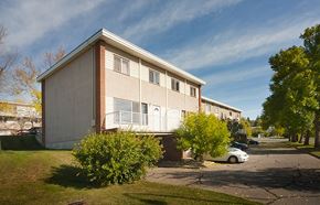 Calgary apartment for rent - A small apartment building with a car parked in front.