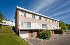 Calgary apartment for rent - Apartment building with a parking lot in front.