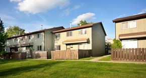 Edmonton apartment for rent - A row of houses with a green lawn in front.